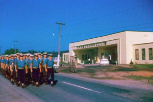UNTD Cadets beginning route march or perhaps going to or from the rifle range (John MacFarlane) from front gates of HMCS Cornwallis, May/June, 1962. Photo by William Thomas, U-794.